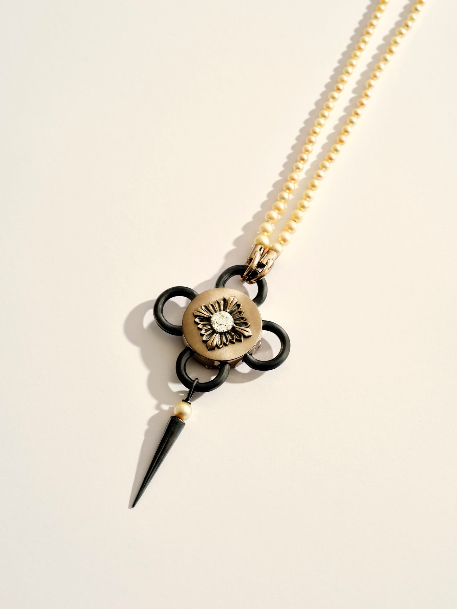 Rouvenat Bolt Black and White necklace with fine pearls on a beige background