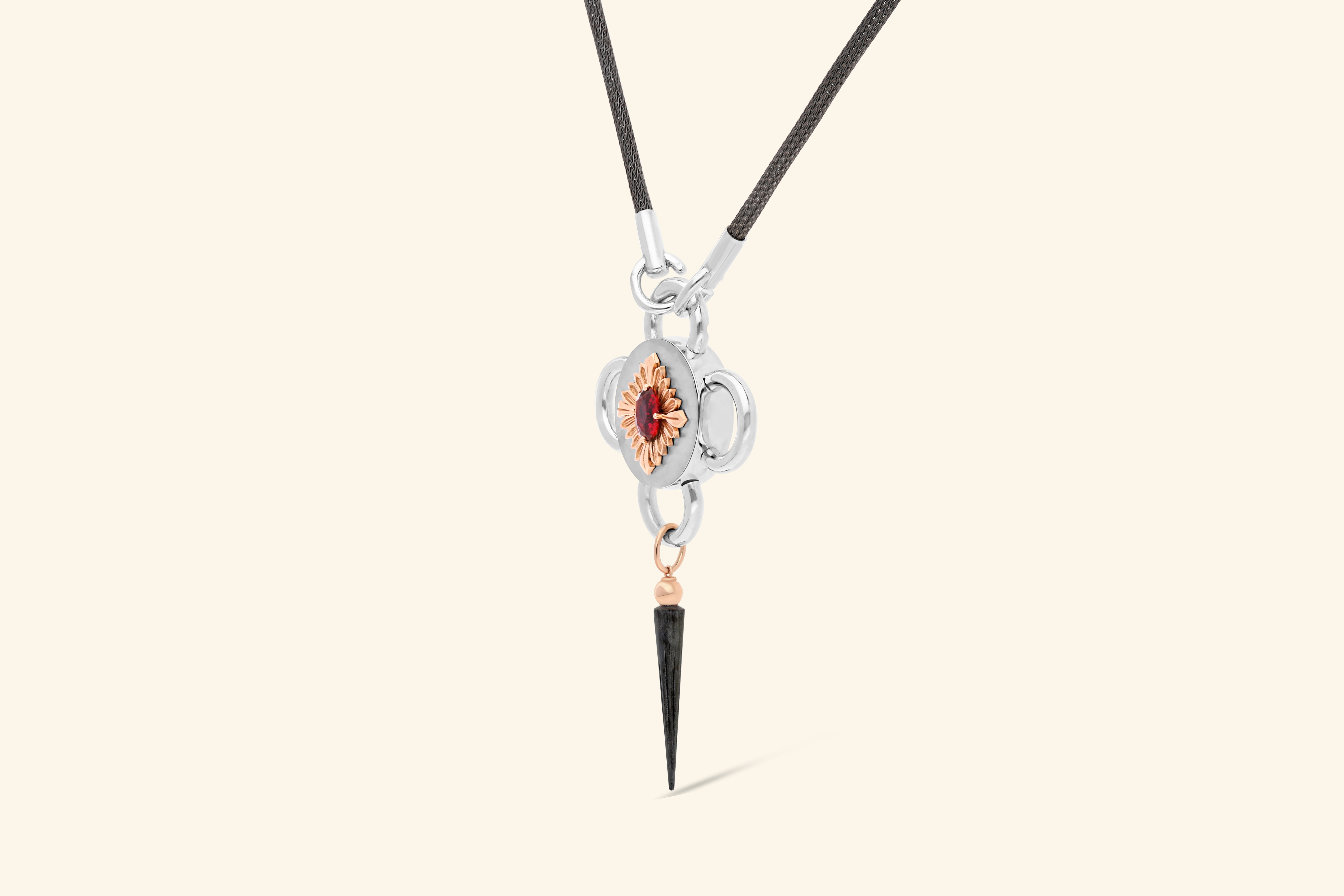 Bolt necklaceA ~1.79-carat rubellite set with a polished rose gold flower on a satin-finish silver disk . A tassel in rose gold and blackened silver. Knitted chain in blackened silver.